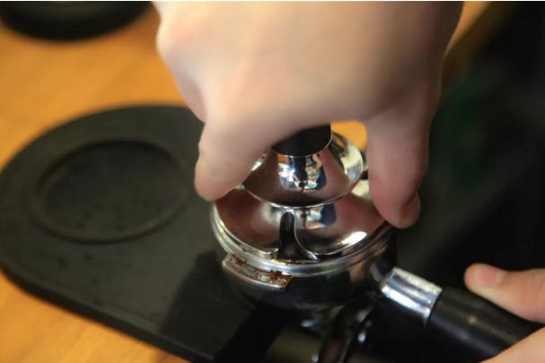 Proper finger positioning for tamping espresso coffee